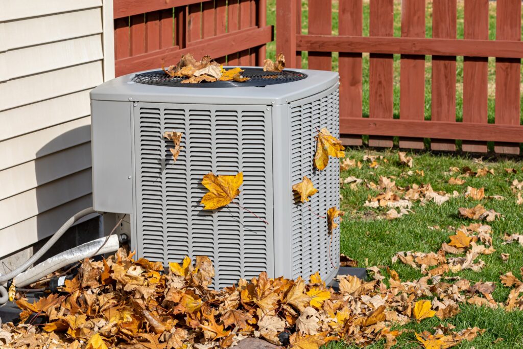 condenser unit covered in leaves